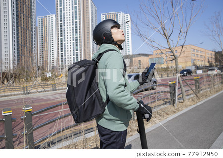 food delivery male courier riding electric scooter to deliver orders food delivery male courier riding electric scooter to deliver orders 77912950