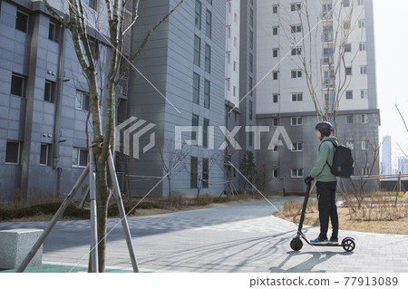 food delivery male courier riding electric scooter to deliver orders food delivery male courier riding electric scooter to deliver orders 77913089