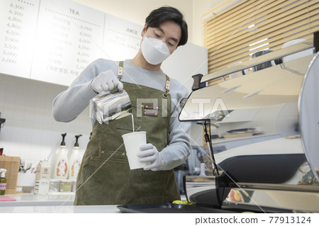 cafe owner with mask making coffee, business in covid concept cafe owner with mask making coffee, business in covid concept 77913124