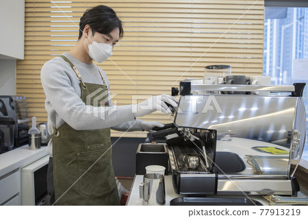 cafe owner with mask making coffee, business in covid concept cafe owner with mask making coffee, business in covid concept 77913219