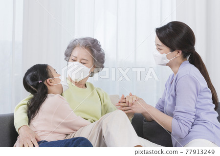 three generations of women, Asian grandmother, mother and grand daughter wearing mask 77913249