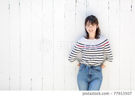 A woman leaning against a white wall A woman leaning against a white wall 77913507