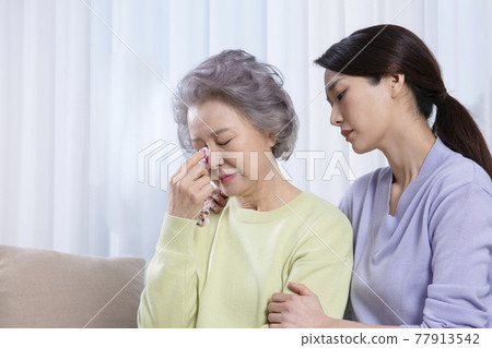 depressed Asian old mother comforted by middle aged daughter depressed Asian old mother comforted by middle aged daughter 77913542