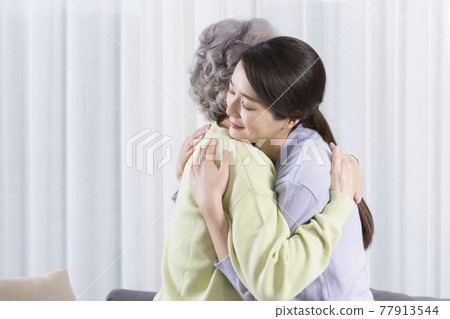 Asian old mother and middle aged daughter huggging Asian old mother and middle aged daughter huggging 77913544