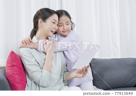 Asian mother and young daughter celebrating parents mothers day with letters Asian mother and young daughter celebrating parents mothers day with letters 77913649
