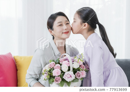 Asian mother and young daughter celebrating parents mothers day with carnation flower Asian mother and young daughter celebrating parents mothers day with carnation flower 77913699