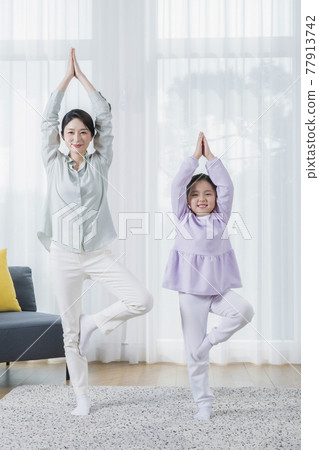 Asian mother and young daughter doing yoga Asian mother and young daughter doing yoga 77913742