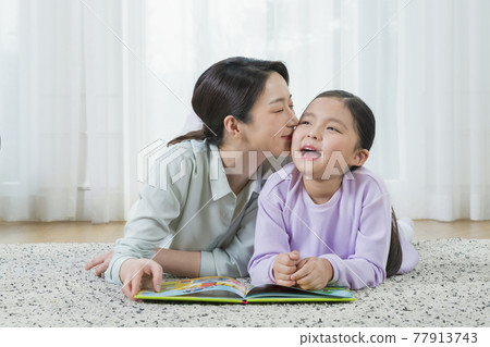Asian mother and young daughter reading book Asian mother and young daughter reading book 77913743