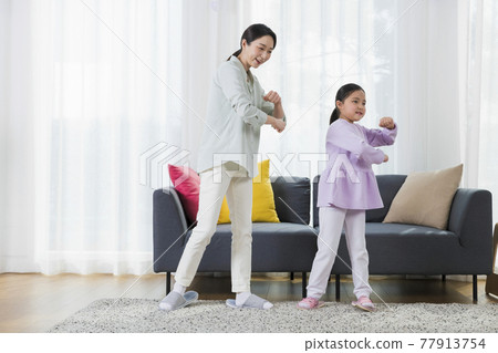 Asian mother and young daughter dancing together Asian mother and young daughter dancing together 77913754