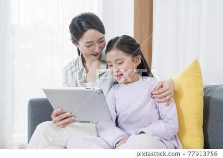 Asian mother and young daughter using tablet Asian mother and young daughter using tablet 77913756