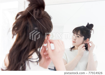 Woman wearing pierced earrings Woman wearing pierced earrings 77914926