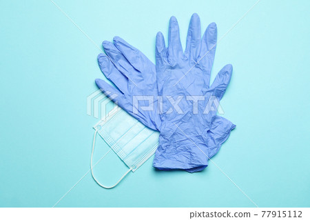 Medical gloves with mask on blue background Medical gloves with mask on blue background 77915112