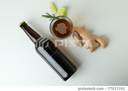 Glass and bottle of ginger beer, and ingredients on white background 77915391