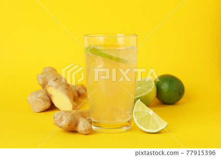 Glass of ginger beer and ingredients on yellow background Glass of ginger beer and ingredients on yellow background 77915396