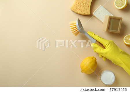 Cleaning concept with hand in glove hold brush on beige background Cleaning concept with hand in glove hold brush on beige background 77915453