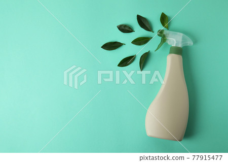 Blank detergent spray bottle and leaves on mint background 77915477