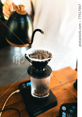 Drip coffee, barista pouring water on coffee ground with filter Drip coffee, barista pouring water on coffee ground with filter 77917007