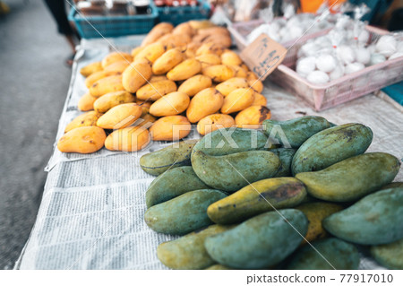 Ripe mangoes on the table in the market 77917010