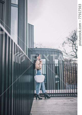 Young modern dark-haired girl outside looking confident Young modern dark-haired girl outside looking confident 77917563