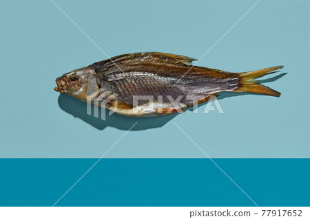 One jerky or dried salted taranka, tasty snack on colorful background. Beer appetizer. Traditional way of preserving fish. Close up One jerky or dried salted taranka, tasty snack on colorful background. Beer appetizer. Traditional way of preserving fish. Close up 77917652