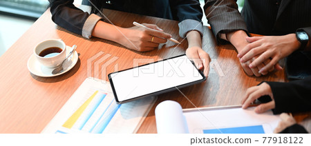 Top view image of businesspeople is working together with mockup tablet and finance chart. Top view image of businesspeople is working together with mockup tablet and finance chart. 77918122