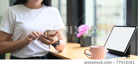 Closeup woman is using smartphone at the wooden counter bar. 77918361