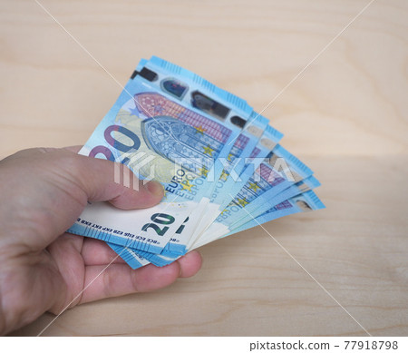 Hand holding Euro notes, European Union 77918798