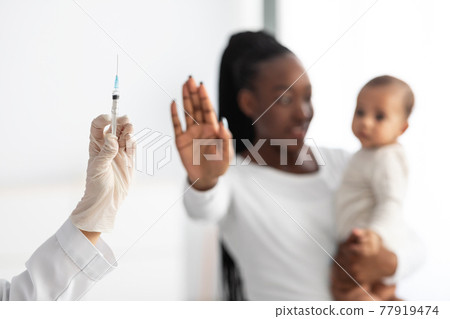 Young African American showing stop gesture to syringe Young African American showing stop gesture to syringe 77919474
