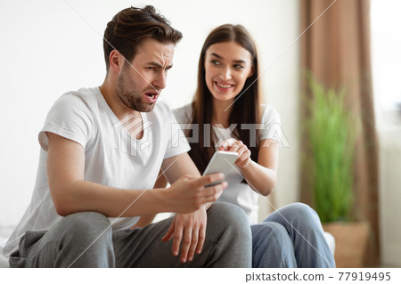 Jealous Wife Catching Cheating Husband Showing His Phone In Bedroom Jealous Wife Catching Cheating Husband Showing His Phone In Bedroom 77919495