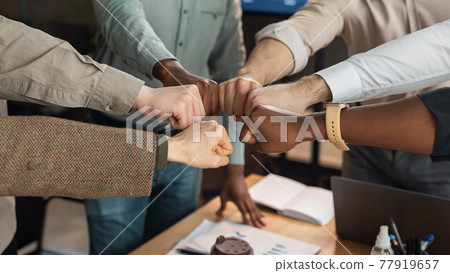 Portrait of diverse business people giving fist bump in circle Portrait of diverse business people giving fist bump in circle 77919657