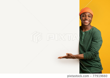 Nice Offer. Cheerful Black Guy Pointing At White Advertisement Board With Palm 77919660