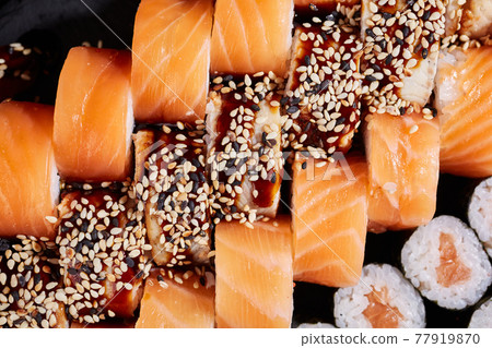 Top view of Philadelphia sushi rolls and sashimi rolls with sauce and sesame seeds. Top view of Philadelphia sushi rolls and sashimi rolls with sauce and sesame seeds. 77919870