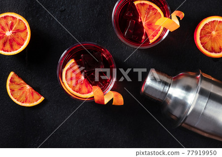 Orange cocktails with a shaker, shot from the top with a place for text Orange cocktails with a shaker, shot from the top with a place for text 77919950