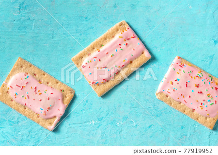 Pink pop tarts on a blue background, top shot Pink pop tarts on a blue background, top shot 77919952