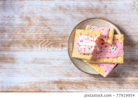 Strawberry pop tarts, shot from the top on a rustic wooden background Strawberry pop tarts, shot from the top on a rustic wooden background 77919954