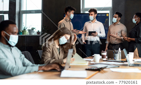 Colleagues in masks having meeting in boardroom, working on project Colleagues in masks having meeting in boardroom, working on project 77920161