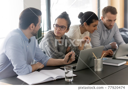 Diverse colleagues employees brainstorming, using laptops, working on project 77920474