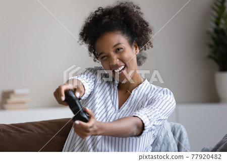 Happy millennial african woman playing online video game. Happy millennial african woman playing online video game. 77920482