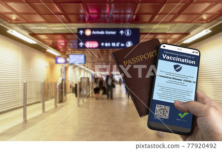 Traveler holds vaccine passport certificate to show COVID 19 vaccination status Traveler holds vaccine passport certificate to show COVID 19 vaccination status 77920492