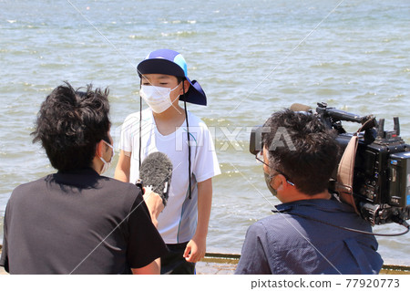 A boy who participates in a sup experience event and is interviewed by a TV station A boy who participates in a sup experience event and is interviewed by a TV station 77920773