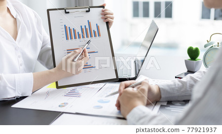 Brainstorm team, Marketers and financial accountants are discussing and analyzing charts to plan strategies to meet customer needs, Using graphs and laptops to analyze business data, Meeting concept. 77921937
