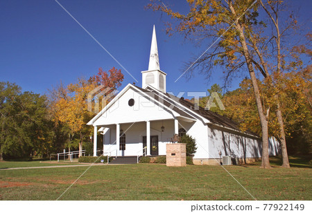 Rural Church in Autumn. White Church with leaves Rural Church in Autumn. White Church with leaves 77922149