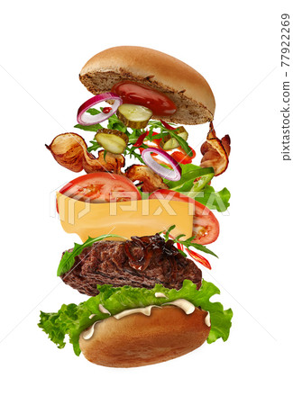 Big burger with flying ingredients isolated on white. Ham, beef cutlet, cheese, mayonnaise, ketchup, vegetables and greens. Close up, copy space Big burger with flying ingredients isolated on white. Ham, beef cutlet, cheese, mayonnaise, ketchup, vegetables and greens. Close up, copy space 77922269