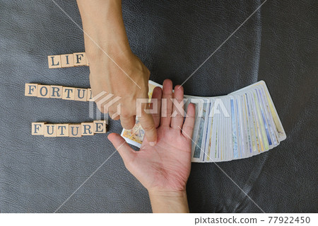 Close-up right hands of fortune teller who point at fingerprint of people to predictions about future destiny, Divine magic concept, top-view 77922450