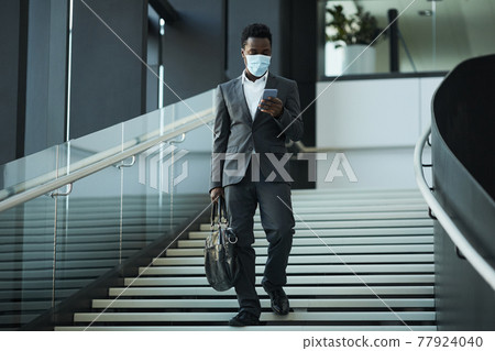 African American Businessman Wearing Mask in Office Hall African American Businessman Wearing Mask in Office Hall 77924040