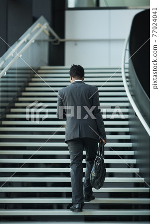 African American Businessman Walking Up Stairs African American Businessman Walking Up Stairs 77924041
