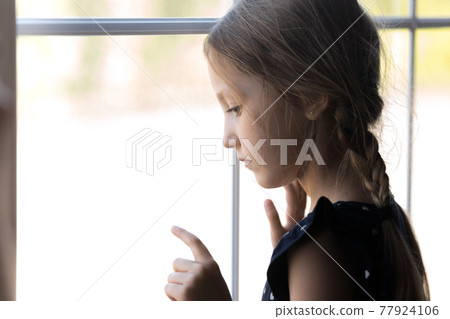 Depressed orphan kid looking out window, feeling lonely 77924106