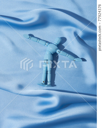 Puppet on blue satin texture background as man swimming in ocean sea concept Puppet on blue satin texture background as man swimming in ocean sea concept 77924376
