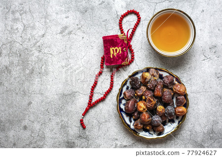Popular food during Iftar - dry dates. Karan, rosary on concrete background Top view Flat lay Muslim holiday of holy month of Ramadan. 77924627
