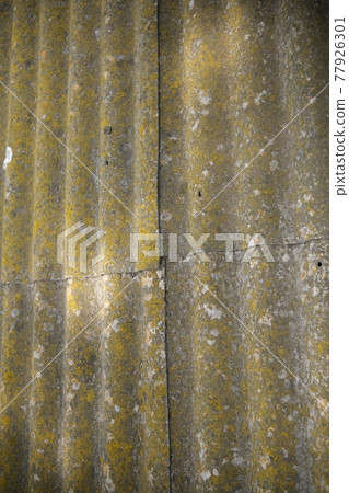The old roof is covered with green moss. The old slate needs to be replaced. The roof of the house. Undulating surface with moss. The old roof is covered with green moss. The old slate needs to be replaced. The roof of the house. Undulating surface with moss. 77926301